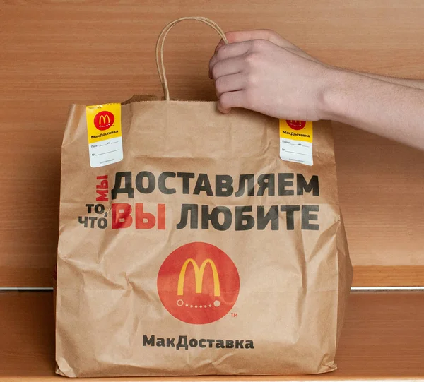 Росія, Москва April2020: на столі знаходиться пакувальний пакет для McDonalds, покупець отримав його для домашньої їжі. Концепція доставки Ілюстративна редакційна картина продукту. — стокове фото