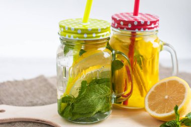 Limon kesiği masanın üzerinde, arka planda, bir fincan çayın yanında duruyor. Sağlıklı beslenme kavramı.