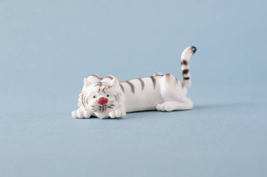 white tiger, toy for children on a gray background. The concept of the development of babies.