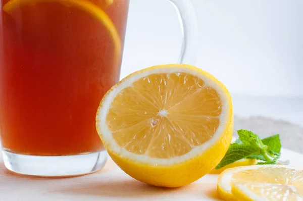 Black iced tea in a glass, next to lies a yellow sliced lemon on a wooden board. The concept of healthy eating. — Stock Photo, Image