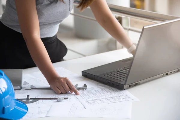 Woman mechanical engineer working on engineer workplace.