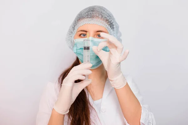 Vrouwelijke Arts Een Witte Medische Jas Masker Hoed Handschoenen Houdt — Stockfoto