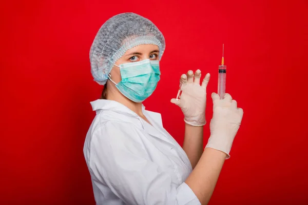 Tıbbi Giysili Kadın Doktor Elinde Şırınga Ampul Tutuyor Kırmızı Arka — Stok fotoğraf