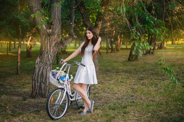 Девушка Белой Юбке Жилете Велосипедом Корзиной Цветов Парке Вечером — стоковое фото