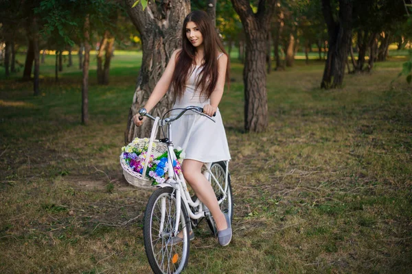 Jovem Mulher Sorridente Senta Uma Bicicleta Com Uma Cesta Flores — Fotografia de Stock