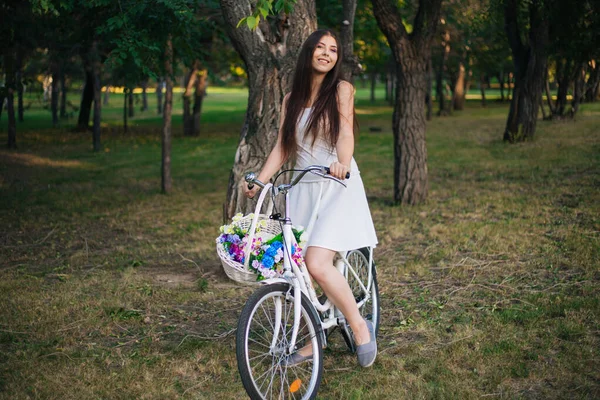 Young Smiling Woman Sits Bicycle Basket Flowers Evening Park — Stock Photo, Image