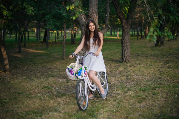 Jovem Mulher Sorridente Senta Uma Bicicleta Com Uma Cesta Flores — Fotografia de Stock