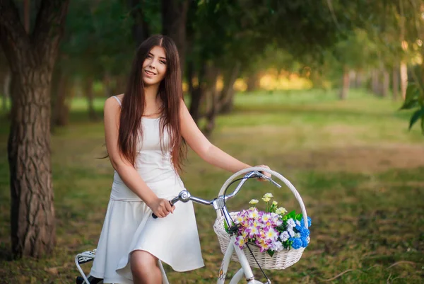Joven Mujer Sonriente Sienta Una Bicicleta Con Una Cesta Flores —  Fotos de Stock