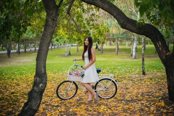 Девушка Белой Юбке Жилете Велосипедом Корзиной Цветов Стоит Желтых Листьях — стоковое фото
