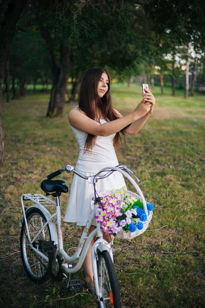 Dziewczyna Białej Spódnicy Kamizelce Smartfonem Rękach Stoi Obok Roweru Kosza — Zdjęcie stockowe