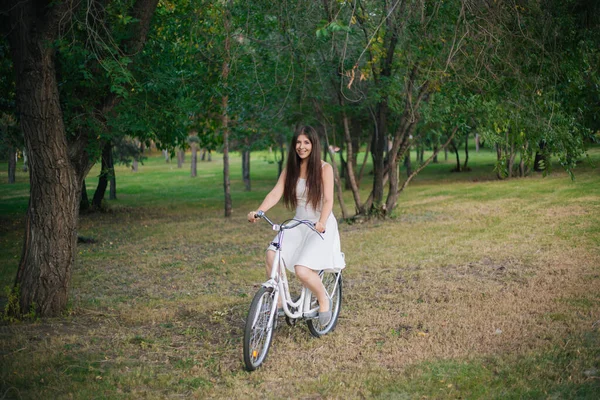 Menina Vestido Branco Monta Uma Bicicleta Através Parque Noite — Fotografia de Stock