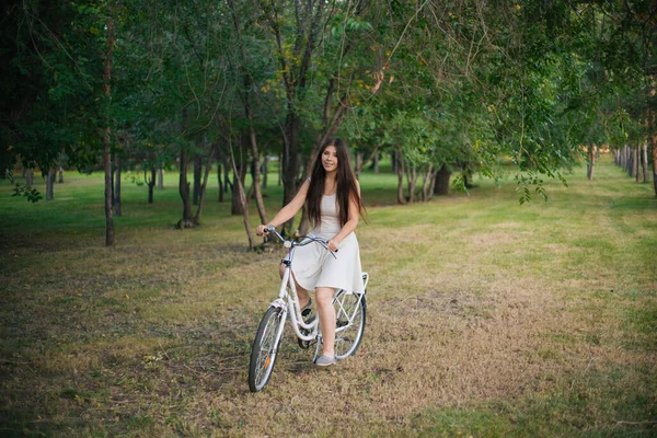 Девушка Белом Платье Вечером Проезжает Велосипеде Парку — стоковое фото