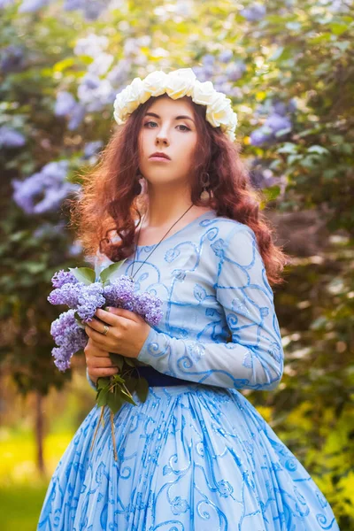 Mulher Atraente Vestido Magnífico Azul Caminha Parque Contra Fundo Flores — Fotografia de Stock