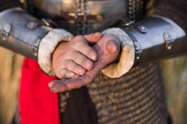 Orta çağ savaşçısının elleri, yakın plan, toprak lekeli. Dünyayı avuçlarının içinde tutuyor. Ellerini yere koy..