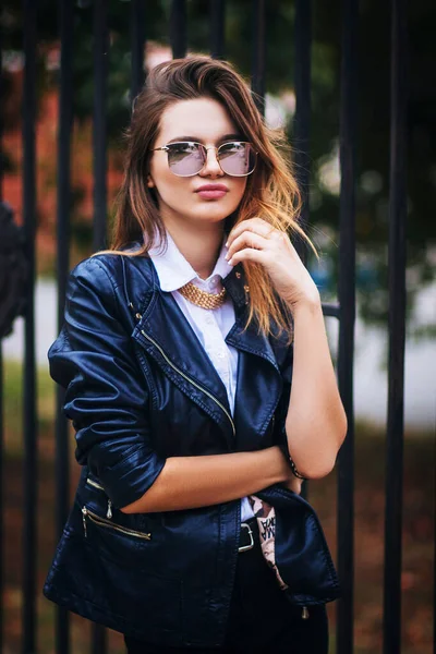 若い美しいファッショナブルなヨーロッパの女性で黒の革のジャケットダークメタルフェンスを背景に — ストック写真