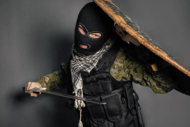 Elinde ortaçağ silahları olan modern bir savaşçı. Bir asker kendini kalkanla korur ve kılıçla saldırır. Hukukun, hukukun, düzenin, malın, paranın, huzurun korunması.