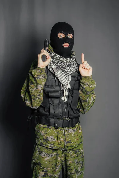 A member of the special police squad, takes aim, holds a pistol. Dressed in a balaclava, camouflage uniform, bulletproof vest. Special weapons and tactics. Special Forces.SWAT.