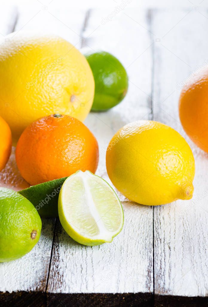 Fresh citrus fruits on white rustic wooden background