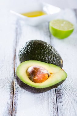 Beyaz ahşap zemin üzerinde organik avokado