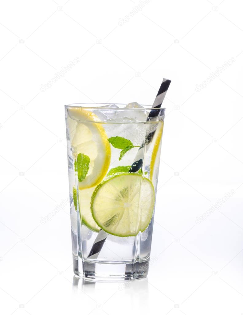 Glass of lemonade with lemon, lime and mint on white background