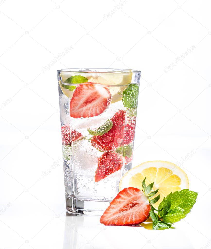Glass of lemonade with lemon, lime and mint on white background