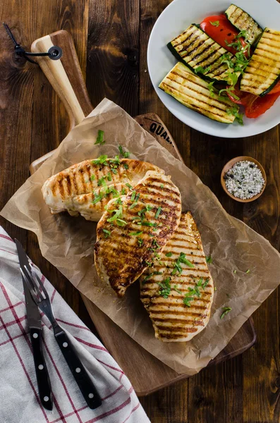 暗い木製のテーブルに焼き野菜と鶏の胸肉焼き — ストック写真