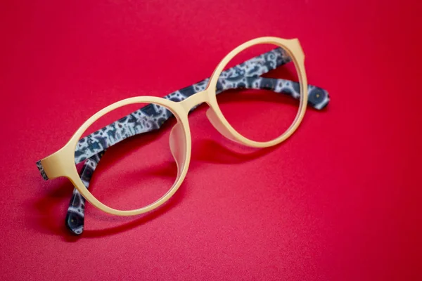 Modernos espectáculos de moda sobre fondo rojo, gafas — Foto de Stock