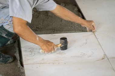 Beyaz döşeme kiremitlerini işçilerin resmi kaplıyor..