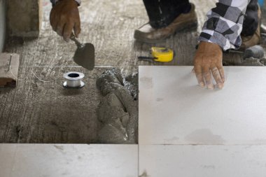 Beyaz döşeme kiremitlerini işçilerin resmi kaplıyor..