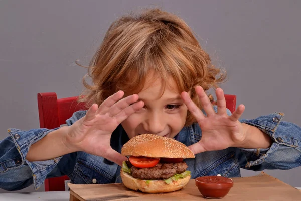 Kind isst Burger. — Stockfoto