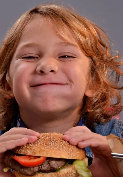 Dítě jíst hamburger. — Stock fotografie