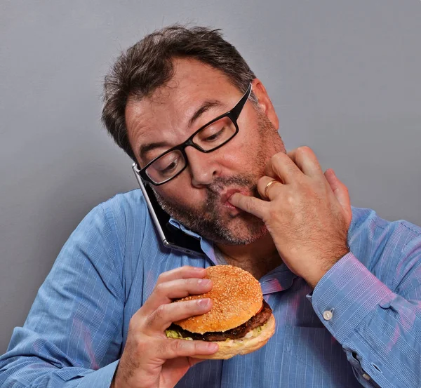 Homme mangeant un hamburger — Photo