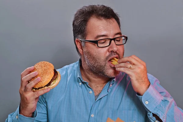 Mannen äter stekt potatis — Stockfoto