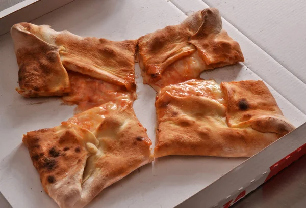 Gebakken pizza gesneden — Stockfoto