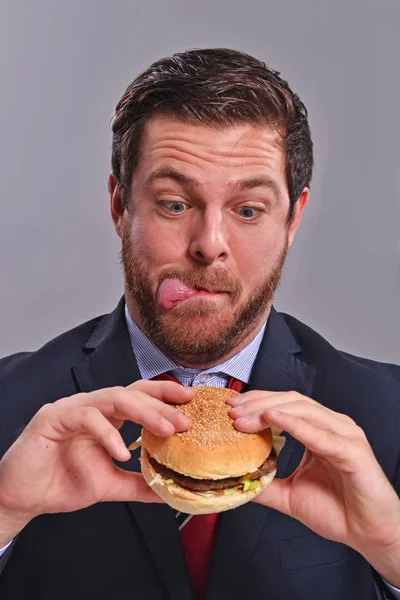 Podnikatel, jíst hamburger — Stock fotografie