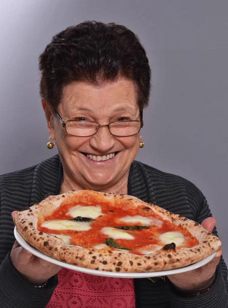 Mormor äter pizza — Stockfoto