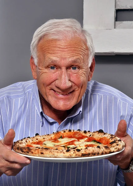 Äldre man med välsmakande pizza — Stockfoto