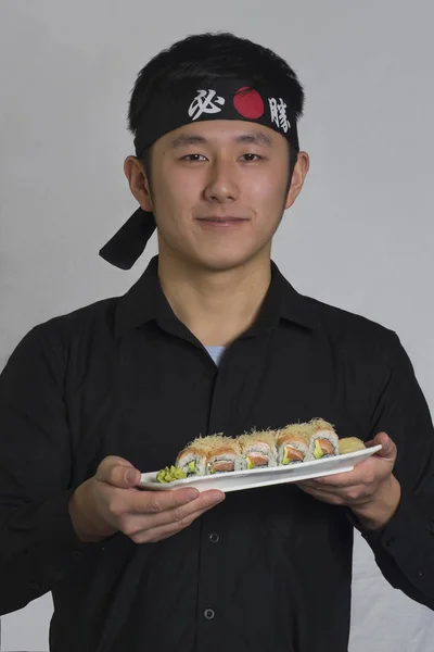 Ung Asiatisk Kock Holding Sushi Rullar Plattan — Stockfoto