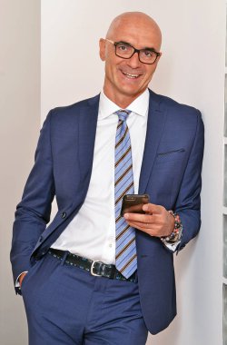 Sıradan tarzda başarılı bir kel iş adamı..