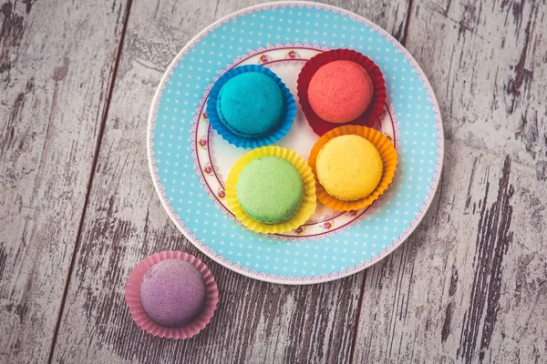 Macarrón rosa sobre plato y café sobre mesa gris madera con servilleta — Foto de Stock