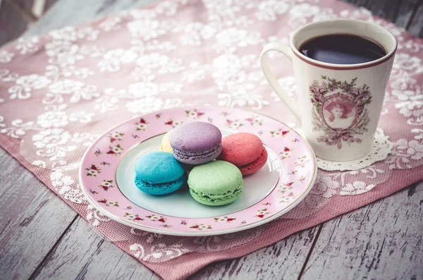 Pink macaroon on plate and coffe on wooden gray table with napkin — Stock Photo, Image