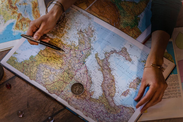 IZMIR, TURKEY JANUARY -17, 2020: Hands of woman leaning over a map and planning a trip. Shallow depth of field