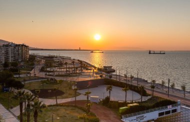 IZMIR, TURKEY 12 Nisan 2020: Günbatımında Coronavirus COVID-19 karantinasından dolayı boş caddeler. İzmir, Konak, Karantina Meydanı ve Tüneli. Fotoğrafta parıltı ve objeler var.