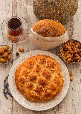 Ramazan 2020 'de COVID-19 virüsüne karşı koruyucu beyaz, tek kullanımlık tıbbi bir maskeyle, çam ve desenli ekmek. Maskedeki ekmeğe odaklan.