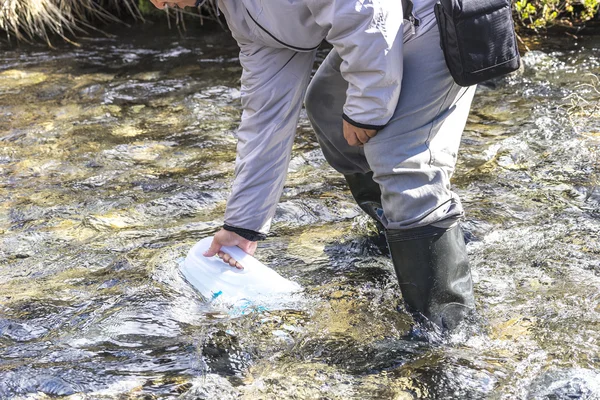 Eine Flasche Wasser Aus Einem Gebirgsbach Nehmen — Stockfoto