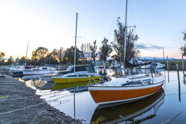 Gün doğumu anı sırasında yansıma ile tekneler bir satır.