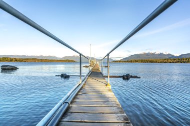 Göl ve doğal sabah güneş ışığı ile ahşap İskelesi