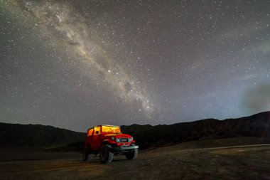 Bromo mount, Endonezya'da samanyolu arka planı olan kırmızı jeep