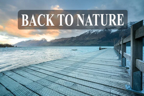 Wooden jetty with mountain at Glenorchy lake, New Zealand.