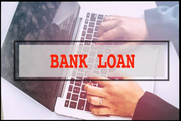 Hand and text BANK LOAN with vintage background. Technology concept.